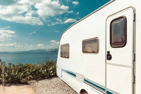 Obraz Przyczepa kempingowa w pobliżu morza, plaży i błękitnego nieba. Summer Holidays Road Trip Travel Concept