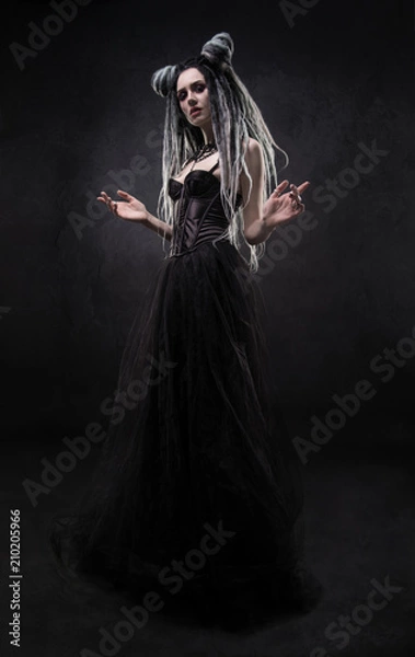 Obraz Woman with dreads and black gothic dress posing on dark background