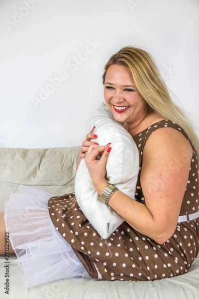 Fototapeta Curvy Model voller Glückshormone umarmt Kissen