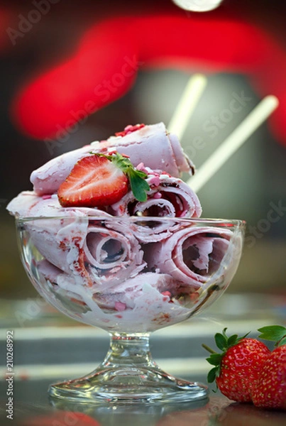 Obraz Roll ice cream is made by hand on the freezer. Sweet dessert made from natural strawberries and ingredients.