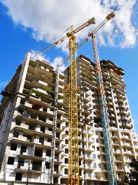 Obraz Two construction cranes near building. Construction site.