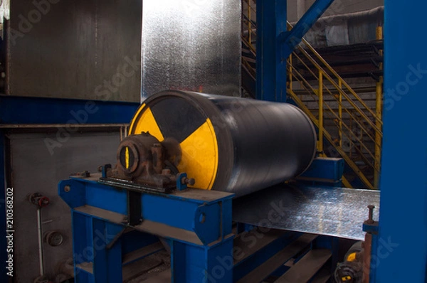 Fototapeta Manufacture of galvanized steel by rolling. Galvanized steel passes through coils. Roll of galvanized steel or metal on machine in industrial workshop on rolling mill, manufacturing metalwork factory