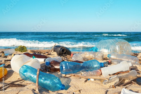 Fototapeta Rozlane śmieci na plaży dużego miasta. Puste używane brudne plastikowe butelki. Dirty Sea Sandy Shore The Morze Czarne. Zanieczyszczenie środowiska. Problem ekologiczny. Bokeh porusza fale w tle