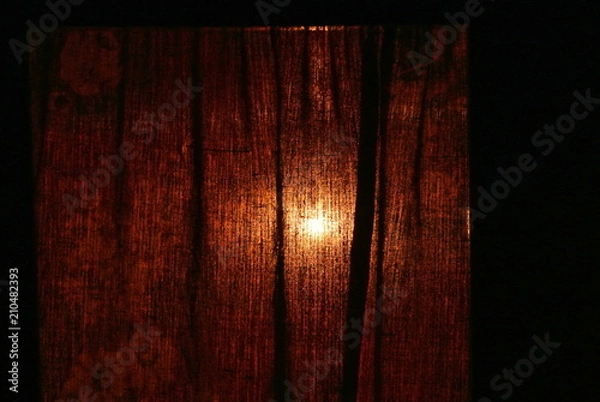 Obraz light bulb through the curtain
