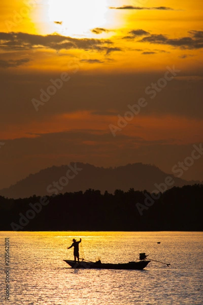 Fototapeta Landscape view of sunset with boat is floating on water reflection from sun