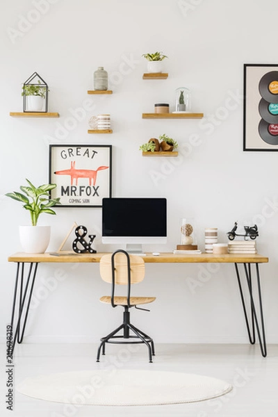 Fototapeta Front view of a desk with a computer, plant and books on the top, shelves on the wall and chair. Place your product
