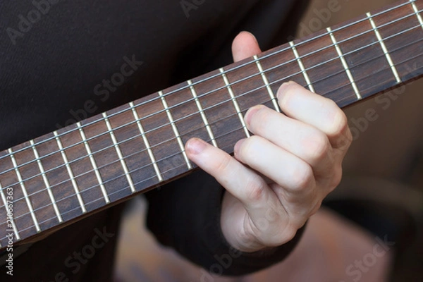 Fototapeta Man is playing guitar close up