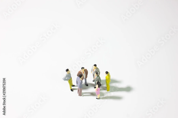 Fototapeta A group of miniature businessman  stand meeting on white background top view center position.