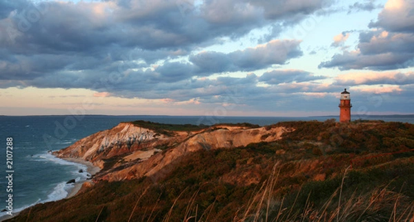 Fototapeta sunset over red cliffs and lighthouse