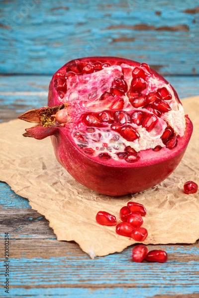 Fototapeta Pomegranate fruit on the a wooden boards