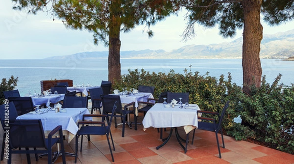 Fototapeta Restaurant with served table in seafront of Aegean sea in Hersonissos, Crete.