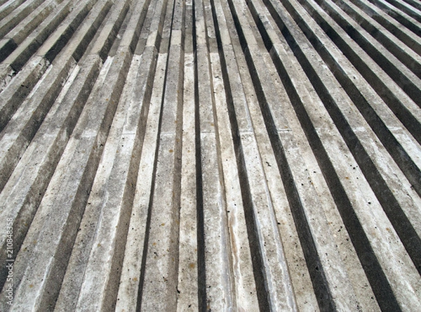 Fototapeta cast concrete with vertical ribbed texture with a converging view in sunlight and shadow