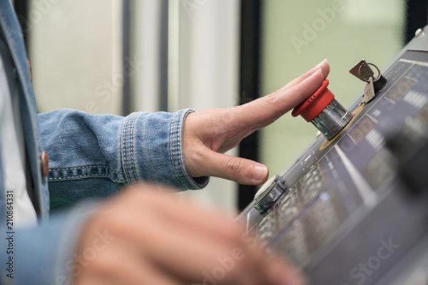 Fototapeta worker press emergency button at control panel to stop accident