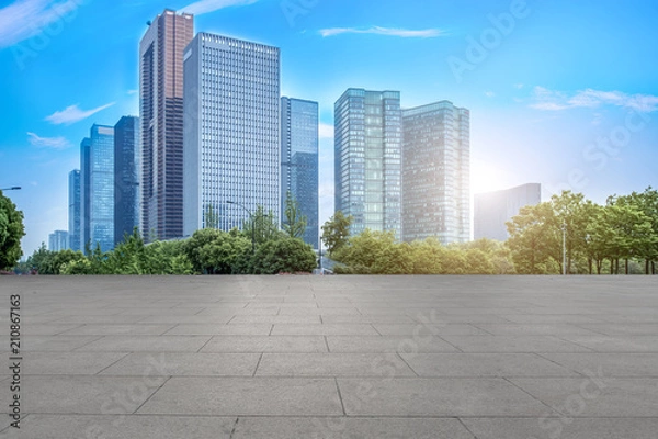 Fototapeta Urban skyscrapers with empty square floor tiles
