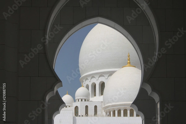 Obraz kopuły białego meczetu na tle niebieskiego nieba w Abu Dhabi, Zjednoczone Emiraty Arabskie 