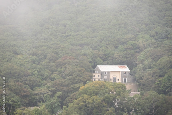 Obraz A traditional home on the hillside with fog around in HongKong