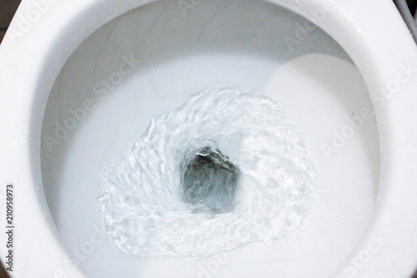Fototapeta selective focus close up flushing toilet bowl for sanitary, Toilet, Flushing Water, close up, water flushing in toilet, A photo of a white ceramic toilet bowl in the process of washing it off. Ceramic