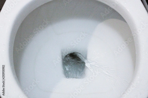 Fototapeta selective focus close up flushing toilet bowl for sanitary, Toilet, Flushing Water, close up, water flushing in toilet, A photo of a white ceramic toilet bowl in the process of washing it off. Ceramic