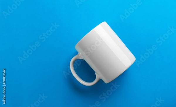 Fototapeta Odwrócony biały kubek na niebieskim tle