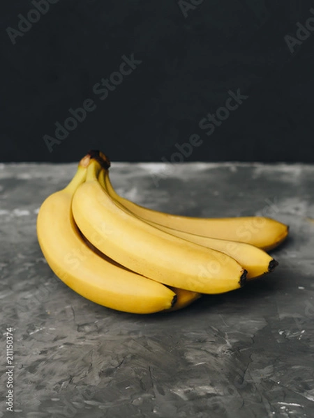 Fototapeta Bunch of bananas on a dark gray background