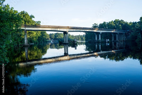 Fototapeta highway bridge over river at sunrise