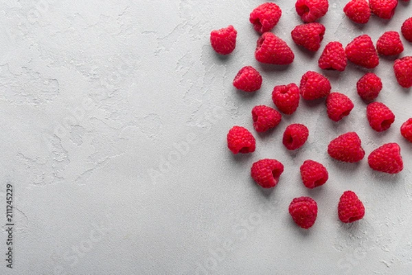 Fototapeta Fresh raspberry on light grey background, overhead view, copy space