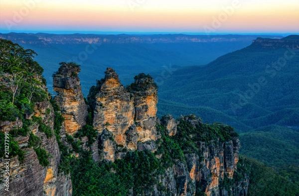 Obraz Niesamowity australijski krajobraz i formacja skalna Three Sisters w Górach Błękitnych o zachodzie słońca