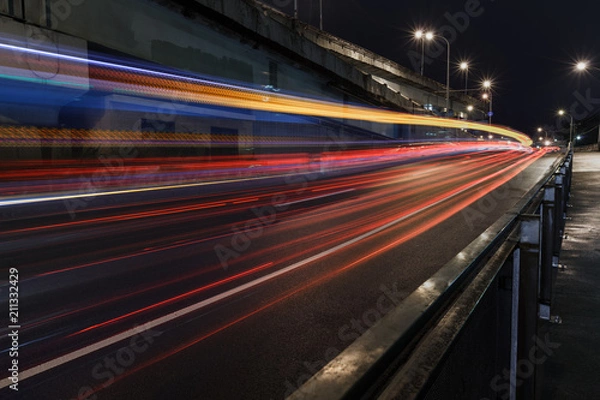 Fototapeta Time-lapse Photograph of Light Trails caused by cars driving along a road in the city.