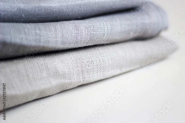 Obraz Three kinds of different cloth in a stack on a white table close up.