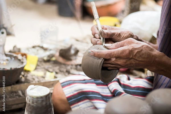 Fototapeta Closed-up hands of a old man to make pottery. Pottery is the ceramic material which makes up pottery wares, of which major types include earthenware, stoneware and porcelain.