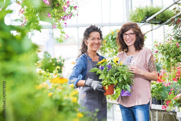 Fototapeta Sprzedawca i klient w centrum ogrodniczym uśmiechają się radośnie do kamery
