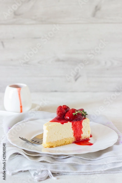 Obraz Piece of delicate cheesecake with strawberries sauce on a white plate. 