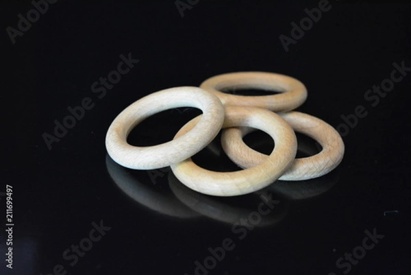 Obraz On a black glossy background there are four wooden rings of brown color with reflection