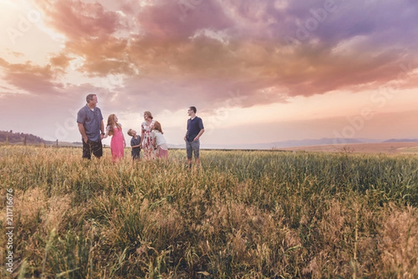 Fototapeta Family time spending quality time with family while walking in a field and sunset