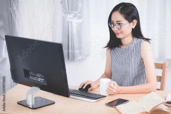 Obraz Young asian business woman working with computer .