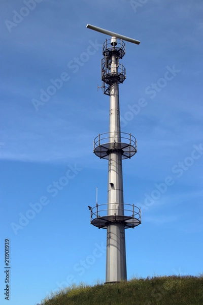 Fototapeta Radar antenna on tall mast at the port of rotterdam to guide ships.