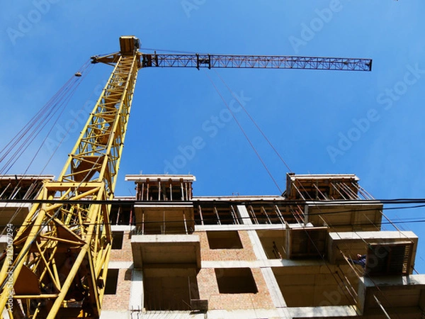 Fototapeta Construction crane near building. Construction site.