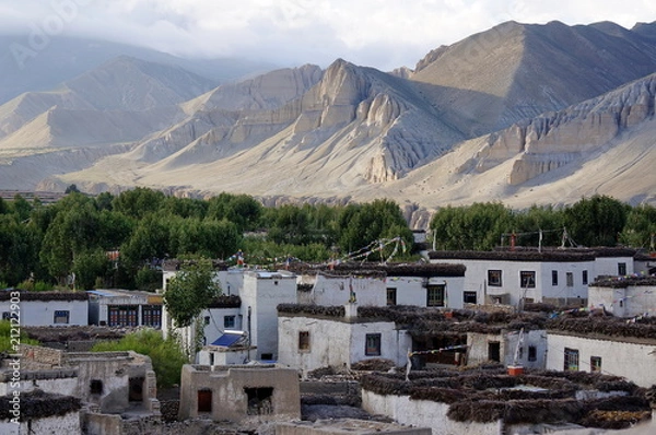 Fototapeta Tsarang village against the background of the Himalayan mountains.  It is one of the later capitals of the Kingdom of Lo in the 14th century. Trekking to the closed zone of Upper Mustang. Nepal.