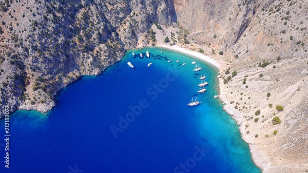 Fototapeta Aerial birds eye view photo taken by drone of famous tropical rocky beach of Agios Georgios with yachts docked, Symi island, Dodecanese, Greece