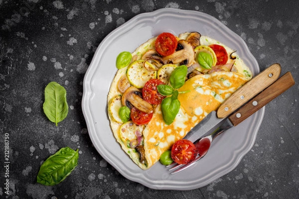 Obraz Thin rolled omelet with fried vegetables, zucchini, tomato, onion, mushrooms, tasty healthy Breakfast,