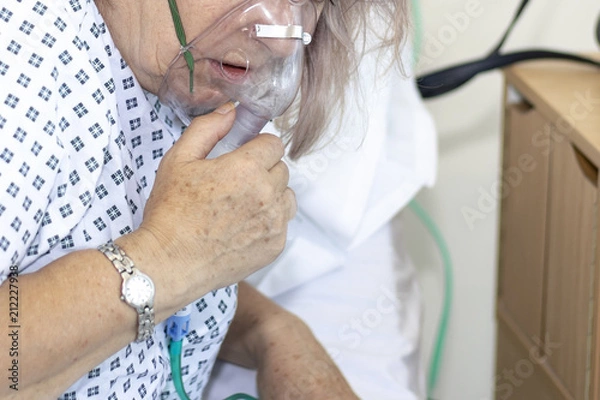 Fototapeta Woman in hospital with breathing difficulties using a resperation mask