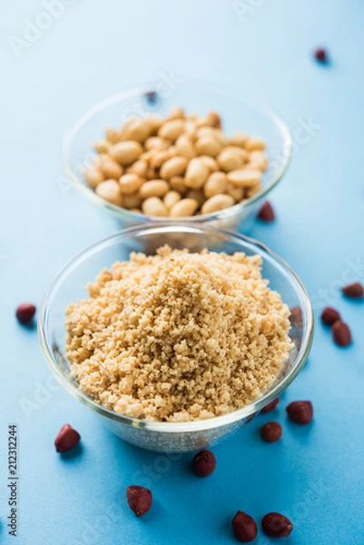 Fototapeta Crushed peanuts or mungfali powder with whole and roasted groundnut. Served in a bowl over moody background. Selective focus