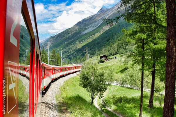 Fototapeta Running train at the railroad in Swiss mountains
