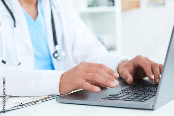 Fototapeta Male doctor, medical students or surgeon using laptop during the conference. Health Check with digital system support for patient, test results and data registration.