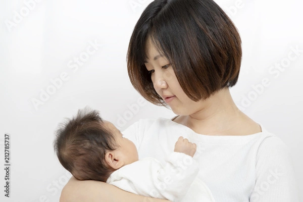 Fototapeta 母に抱っこされ母と見つめ合う新生児の女の子