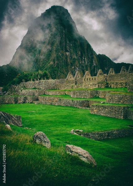 Fototapeta The day start with intense mist in the air in Machu Picchu. The historic archaeological site in a mysterious ambience. Beautiful wallpaper image.