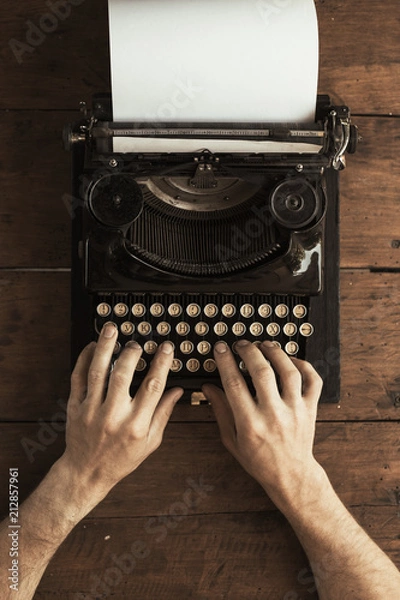 Fototapeta Young man's hands typing on an antique vintage typewriter