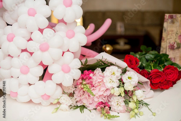 Fototapeta flowers eustoma and rose. A balloon in the form of flowers on a white table