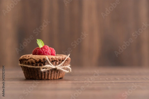 Fototapeta Delicious chocolate lava cake with fresh raspberries and mint on the table