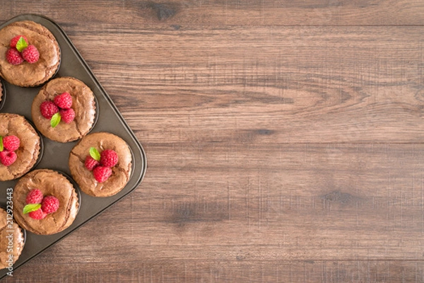 Fototapeta Delicious chocolate lava cakes with fresh raspberries and mint in the iron pan
